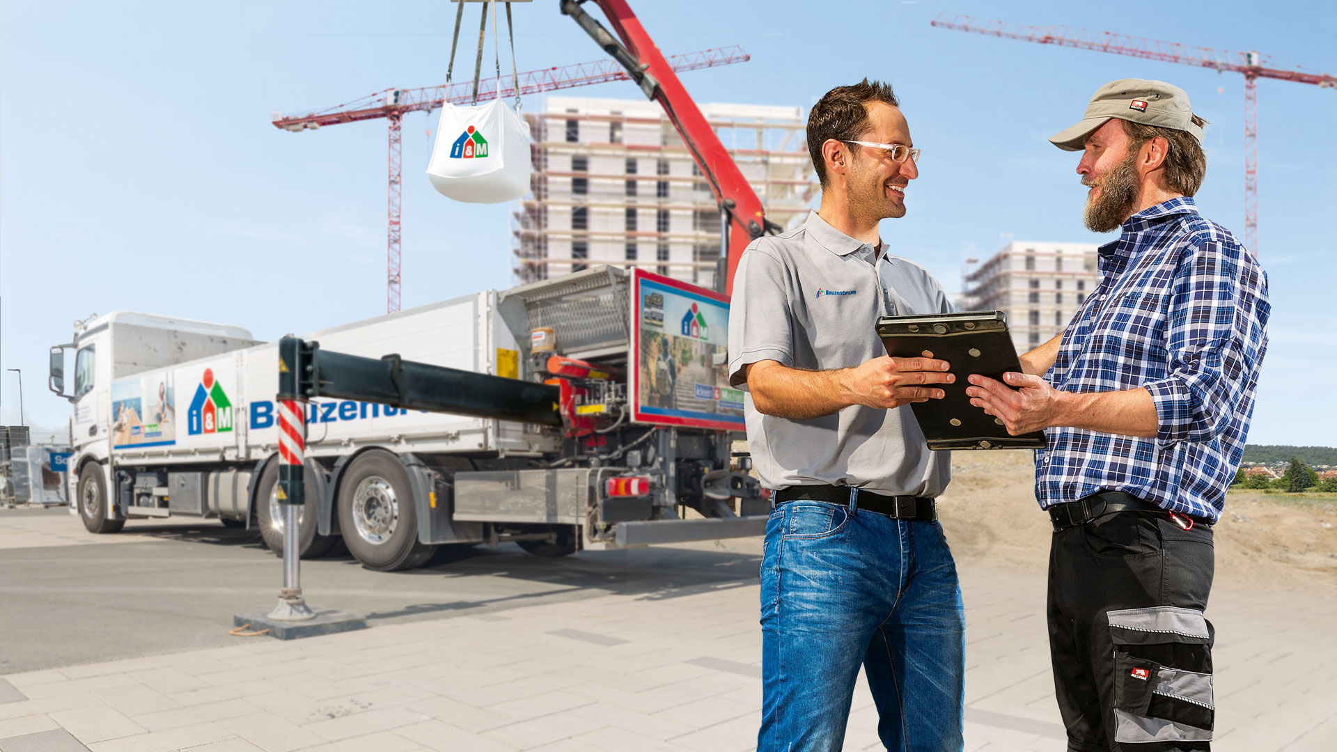 Profikunde und Fachberater vor einem LKW mit der Aufschrift i&M Bauzentrum