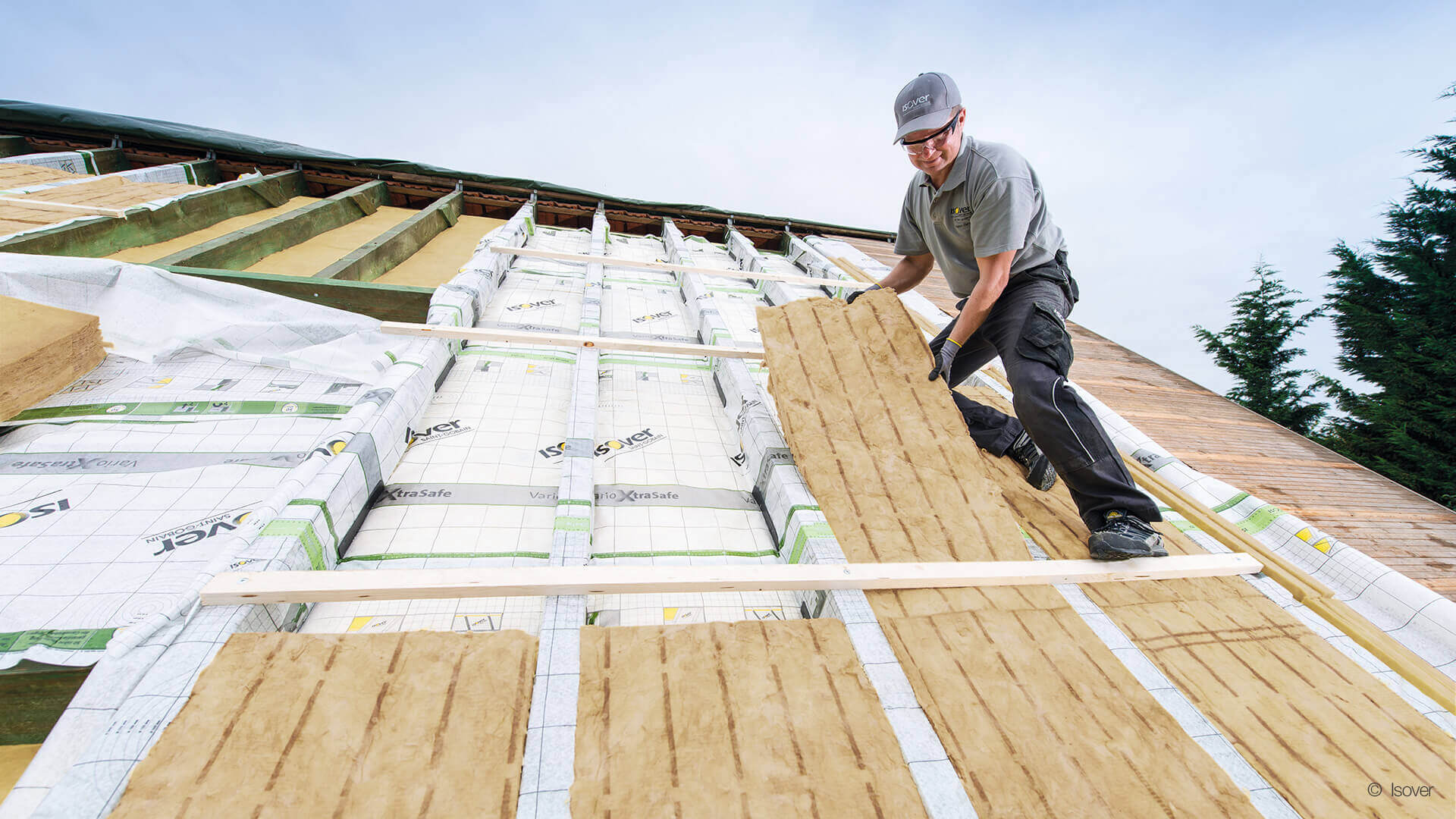 Handwerker bei der Dachdämmung mit Dampfbremse am Steildach