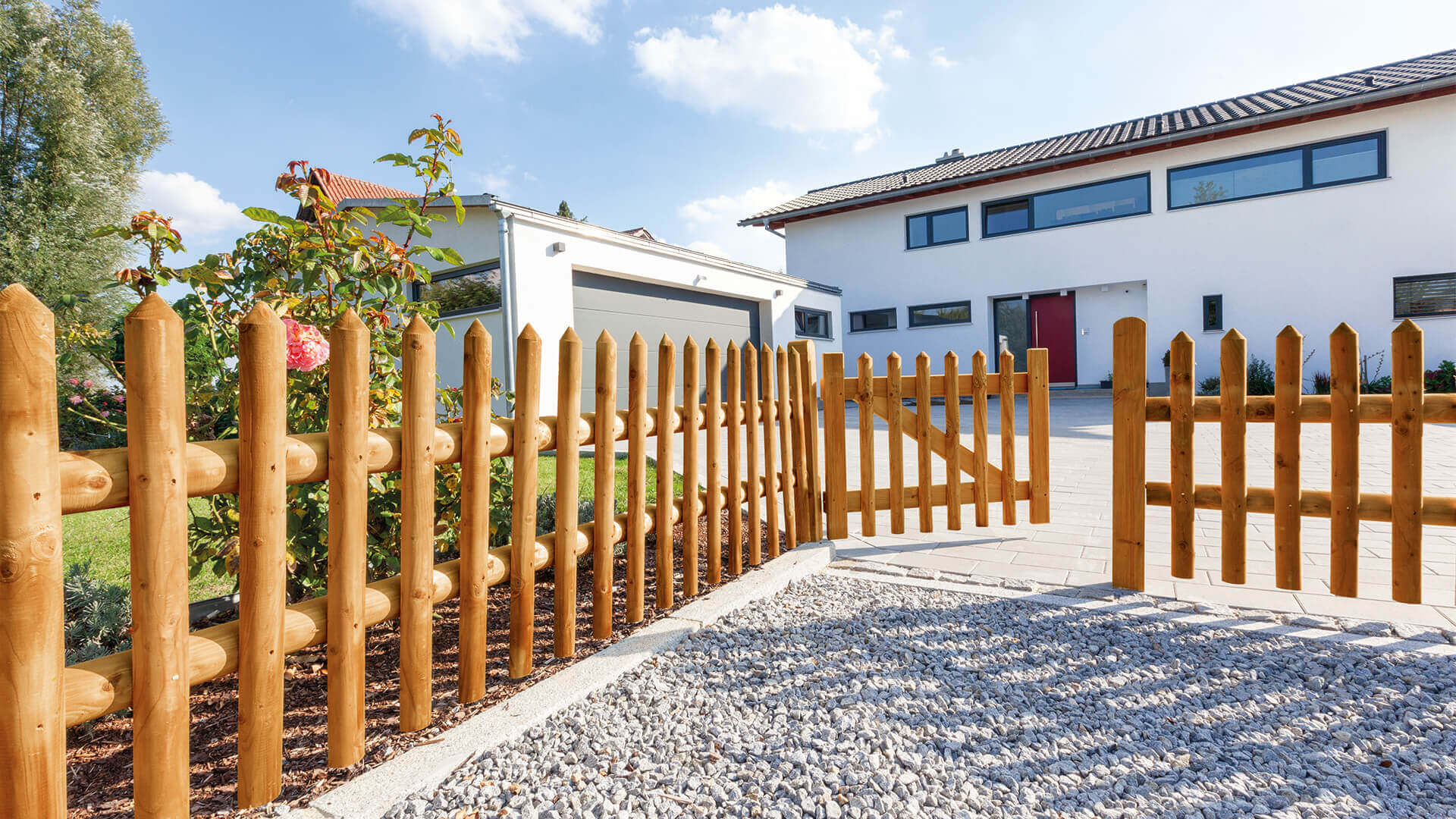 Holzgartenzaun und Kieseinfahrt